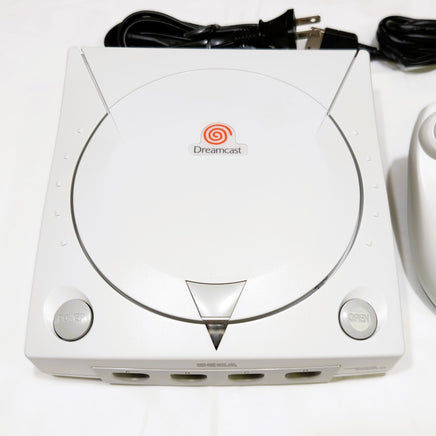 White Sega Dreamcast console with power cord on a white background