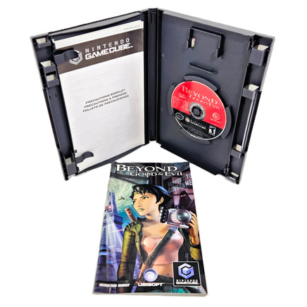 Nintendo GameCube game case for Beyond Good and Evil, shown open with the game disc inside and the front cover booklet placed in front on a white background.