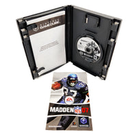 Nintendo GameCube Madden NFL 7 video game shown open with the game disc in the slot, alongside the front cover art of the instruction manual and insert booklet on a white background.