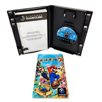 Nintendo GameCube Mario Party 7 game case opened to show the black jewel case interior with a blue game disc, alongside the front cover of the instruction manual