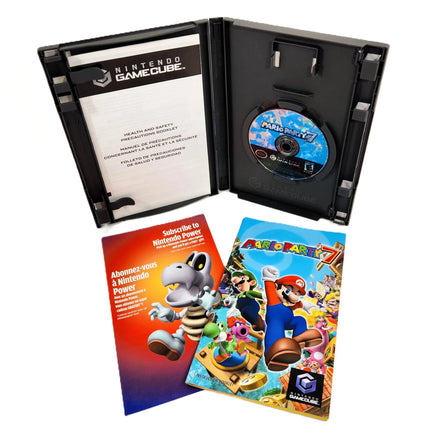 Nintendo GameCube Mario Party 7 game package shown open, with the black game case, disc, instruction booklet, and cover insert on a white background.