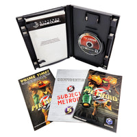 Nintendo GameCube Metroid Prime game case opened to show the disc and cartridge tray, with the game's booklet and instruction sheet placed in front on a white background.