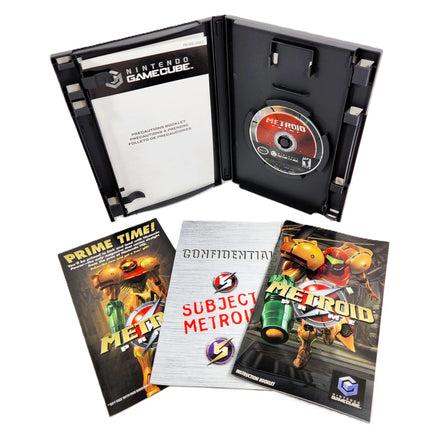 Nintendo GameCube Metroid Prime game case opened to show the disc and cartridge tray, with the game's booklet and instruction sheet placed in front on a white background.