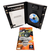 Nintendo GameCube Monster Jam Maximum Destruction game case shown open with the game disc inside, alongside the user manual on a white background.