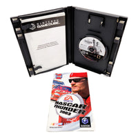 Nintendo GameCube NASCAR Thunder 2003 game case opened to show the interior, with the game disc visible on the right and the instruction booklet in front on a white background.