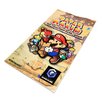Nintendo GameCube instruction booklet for Paper Mario: The Thousand-Year Door, featuring colorful character artwork of Mario and others on a parchment-style cover, with the GameCube logo at the bottom.