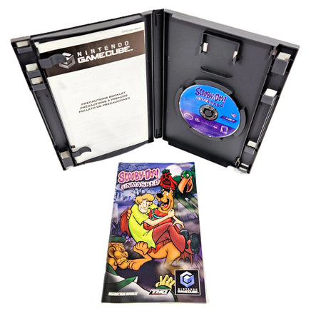 Nintendo GameCube Scooby-Doo Unmasked game case shown open with the game disc inside, plus the instruction manual placed in front on a white background.