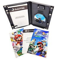 Nintendo GameCube 'Super Mario Sunshine' game case shown open with the game disc inside, plus the printed manual and booklet laid in front on a white background.