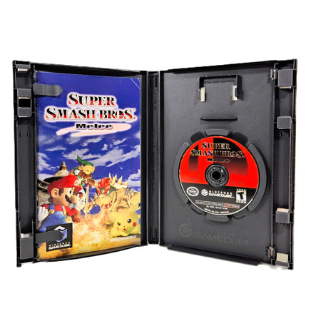 Super Smash Bros. Melee video game for GameCube, shown open with the game case cover on the left and the game disc on a black insert on the right, photographed on a white background.