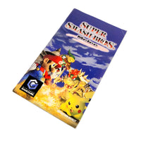Nintendo GameCube game instruction manual for Super Smash Bros. Melee, featuring artwork of Mario, Pikachu, Bowser, and other Smash characters against a blue sky background, photographed on a white background.