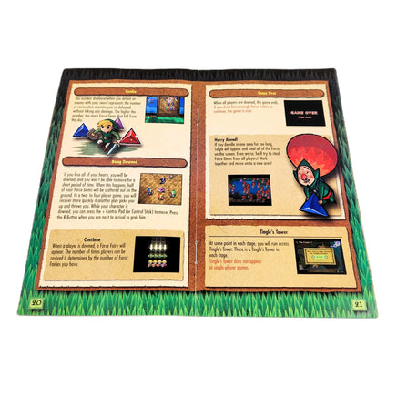 An open printed game instruction booklet for the GameCube release of The Legend of Zelda: Four Swords Adventures, photographed flat against a plain white background. The pages show gameplay text, miniatures, terrain graphics, and game-related illustrations, with grass-like borders around the booklet.