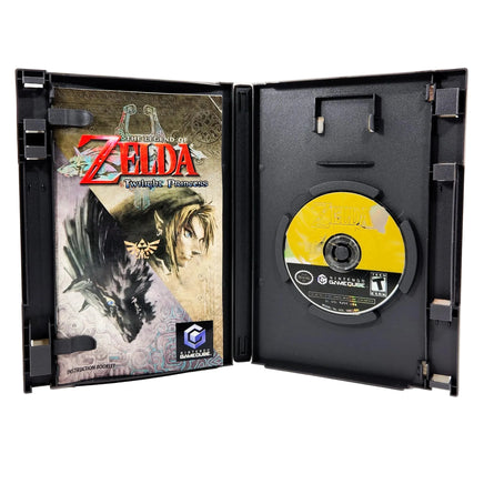 Nintendo GameCube game case for The Legend of Zelda: Twilight Princess, shown open with the game disc on the right and the Instruction Manual booklet on the left, photographed on a white background.