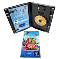 Nintendo GameCube 'The Legend of Zelda: Wind Waker' game case opened to show the game disc and Tingle insert, with the game's instruction booklet placed in front on a white background.