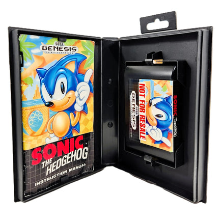A Sonic the Hedgehog Genesis cartridge displayed inside an open black presentation case with an instruction manual on the left and the cartridge on the right. The Sonic the Hedgehog and Genesis logos are visible.
