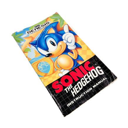 Sonic the Hedgehog instruction manual for the Genesis console, featuring Sonic on the cover, photographed on a plain white background.
