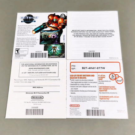 Rear view of Nintendo DS printed pamphlets laid flat on a light gray surface: a health and safety booklet, a Wi-Fi connection booklet, and a promotional insert featuring the Nintendo Power logo and a Metroid Prime Samus illustration.