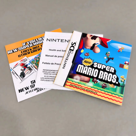 Nintendo New Super Mario Bros. instruction book and manuals for the Nintendo DS, displayed on a neutral gray background.