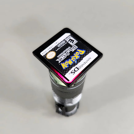 Pokémon Black Version for Nintendo DS - Nintendo DS Pokémon game cartridge held over a light source showing red translucent tint, very good condition, loose