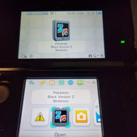 Nintendo 3DS console shown displaying the Pokémon Black Version 2 game on the screen in a dark room.