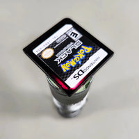 Pokémon Black Version for Nintendo DS - Close-up of Pokémon Nintendo DS cartridge showing reddish-purple translucent shell under light, good condition