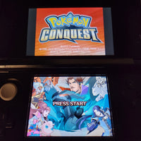 A Nintendo 3DS handheld game console displaying the Pokémon Conquest game screen, with the top screen showing the orange Pokémon Conquest logo and the bottom screen showing character artwork and the text 'PRESS START'.
