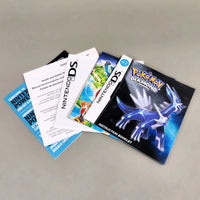 A set of Nintendo DS game booklet and instruction materials fanned out on a neutral gray surface, including a Pokémon Diamond instruction booklet and a Nintendo DS manual.