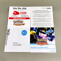 Nintendo DS Pokémon Rumble instruction pamphlet and other included inserts laid out on a gray surface. The booklet cover shows Pokémon Rumble artwork with the Nintendo DS logo, and the inserts include a Club Nintendo card and an instruction sheet.