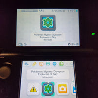 A close-up of a Nintendo 3DS handheld console showing two game screens. The top screen displays a 'Pokémon Mystery Dungeon: Explorers of Sky' icon, and the bottom screen shows the app menu with the selected icon highlighted.
