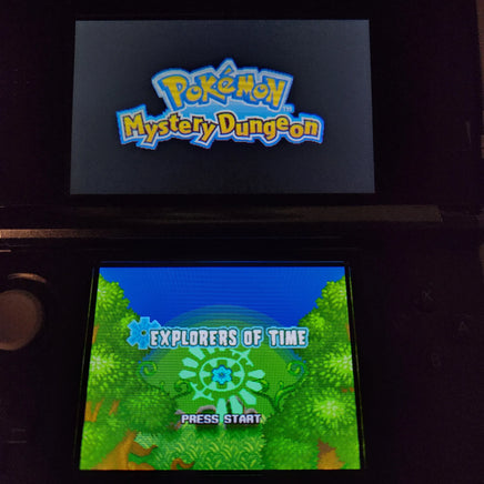 Nintendo 3DS handheld game console displaying the Pokémon Mystery Dungeon: Explorers of Time, with the Pokémon logo on the upper screen and the game's 'Explorers of Time' level selection screen on the lower screen.