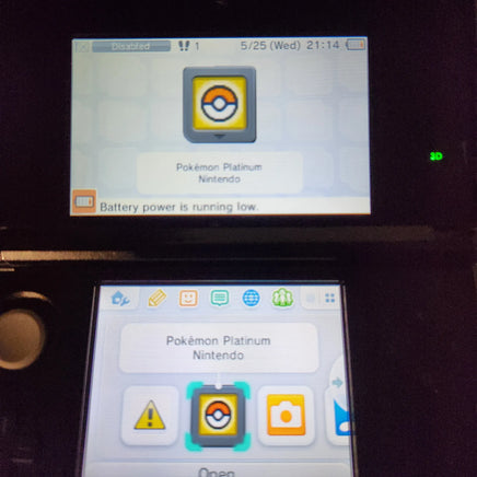 A close-up of a Nintendo 3DS handheld console showing the Pokémon Platinum Nintendo software interface on both the upper screen and lower screen against a dark background.