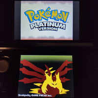 A Nintendo 3DS handheld game console displaying the Pokémon Platinum Version game screen, with the Pokémon logo on the top screen and a stylized yellow and red dragon-like character on the bottom screen.