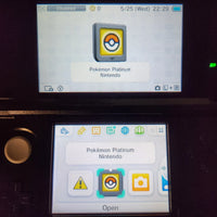 Nintendo DS device showing the Pokémon Platinum app interface on the screens, with one device displaying the app cover and the other showing app icons including a Pokémon badge.