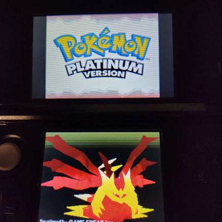 A Nintendo 3DS game console displaying the Pokémon Platinum Version game menu, with the Pokémon logo on the top screen and a pixelated red and yellow character on the bottom screen.
