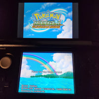 A Nintendo DS handheld game console showing the Pokémon Ranger Guardian Stars game screen, with the Pokémon logo on the top display and a rainbow landscape on the bottom screen.