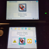 A Nintendo 3DS handheld console showing the Pokémon Ranger Shadows of Almia Nintendo app on both the upper screen and the lower screen, photographed in a dark setting.