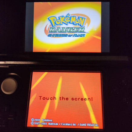 A black Nintendo 3DS handheld game console showing the Pokémon Ranger: Stories of Flareon game screen, with the Pokémon Ranger logo on the top display and an orange 'Touch the screen!' message on the bottom screen.
