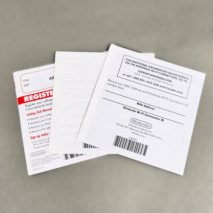 Rear view of a set of Nintendo Club Nintendo promotional inserts and a white Nintendo DS manual on a neutral gray background.