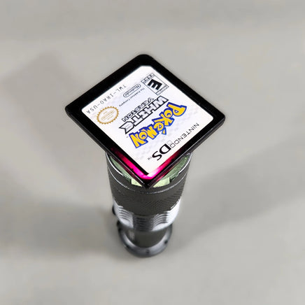 Pokémon White Version for Nintendo DS - Pokémon DS cartridge flashlight test showing the characteristic reddish-purple glow, good condition, loose