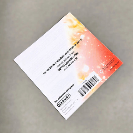 Rear view of a Nintendo DS instruction manual for Pokémon White Version 2, photographed on a neutral gray background.