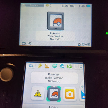 Nintendo DS screen showing the Pokémon White Version Nintendo game, with the upper screen displaying the main icon and the lower screen showing app icons on a dark device body.