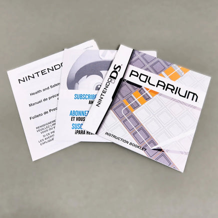 Nintendo DS Polarium instruction booklet and, featuring white with black and orange graphics, photographed on a neutral gray surface.