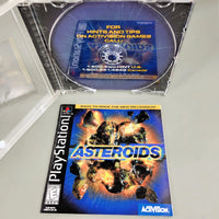 Asteroids for PlayStation 1 - Disc removed to show artwork behind disc tray with front of instruction manual shown, like new condition