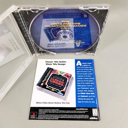 Asteroids for PlayStation 1 - Disc removed to show artwork behind disc tray with rear of instruction manual shown, like new condition