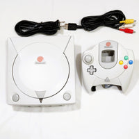 Sega Dreamcast console and controller with cables on a white background