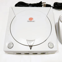 White Sega Dreamcast console with power cord on a white background