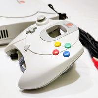 White Dreamcast gaming controller with colorful buttons on a white background