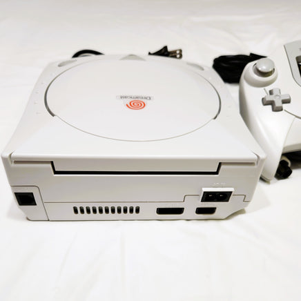White Sega Dreamcast gaming console with controller on a white background