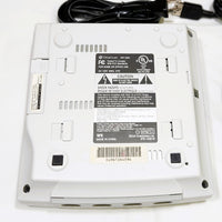 Bottom view of a Sega Dreamcast console with cables on a white background